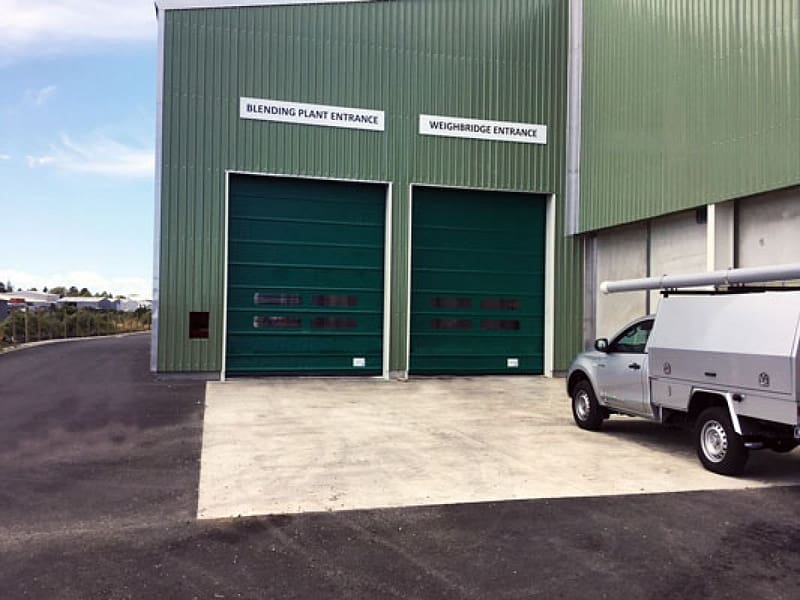 Two green Ulti Fold Doors installed at a Ravensdown facility entrance.